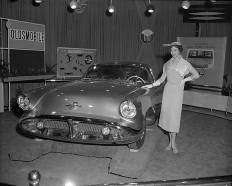 Model_posing_with_the_1954_Oldsmobile_Cutlass_show_car_on_display_at_the_General_Motors_Motrorama_1955.jpg